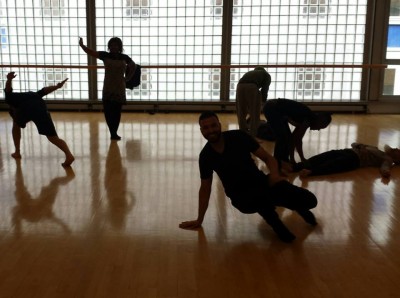 Silhouettes of people dancing: some standing, some crouching, some crawling