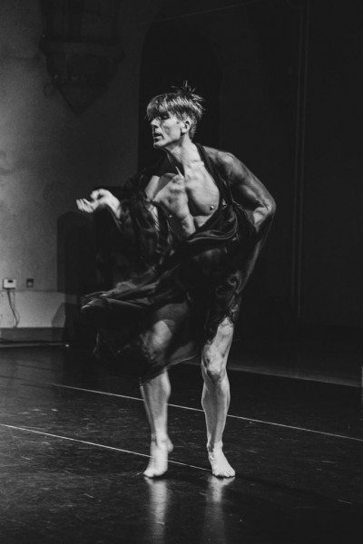 Man dancing in a silk flowing garment with  bare legs and chest